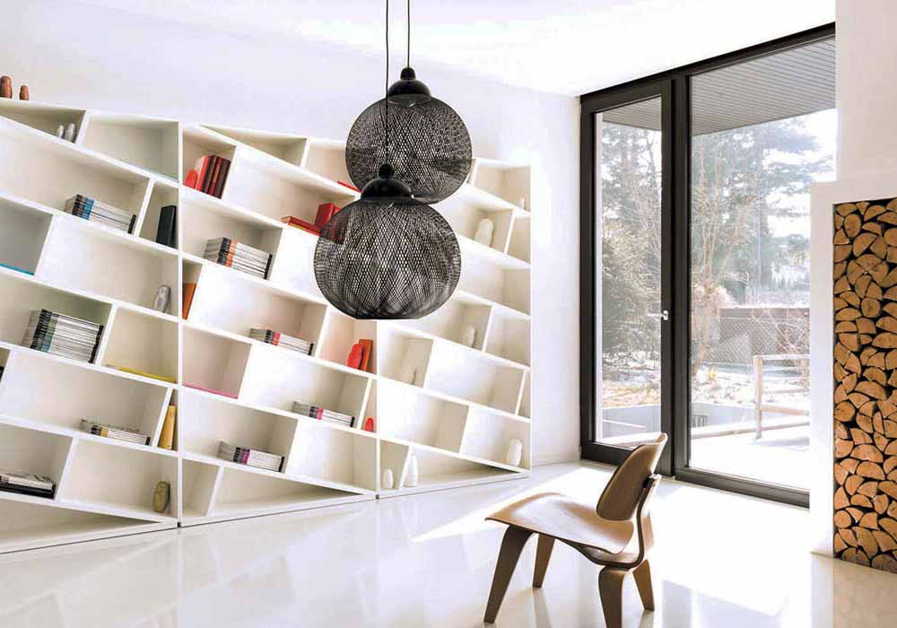 Ein offenes weisses Bücherregal mit diagonal eingebauten Regalböden.
