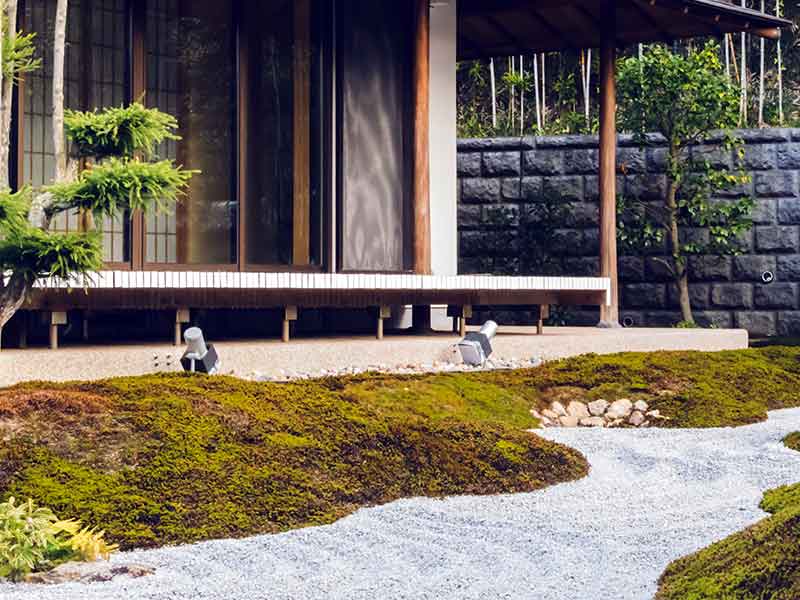 Vor einer Pagode in einem japanischen Garten verlaufen Kieswege.